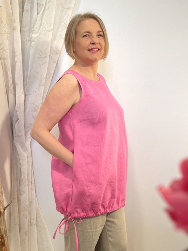 Pinkki hihaton, taskullinen pellavatoppi, helmassa on ny&ouml;rikiristys.